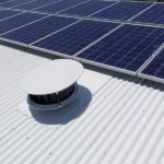 Odyssey Roof Vent installed on a white metal roof with overlying solar panels